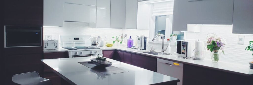 Contemporary kitchen interior with sleek white cabinets and island, perfect for a minimalist aesthetic.